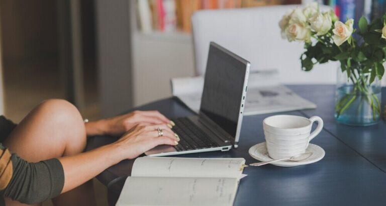 Woman writing a blog post on a laptop